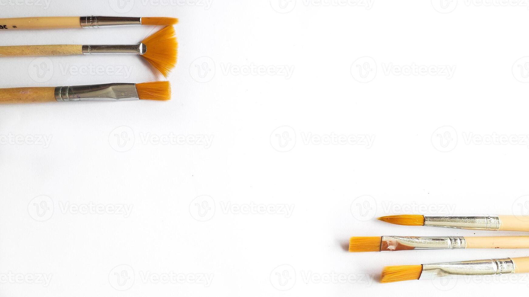 Top view of a variety of artist brushes on a white background with copy space for text. Creative postcard photo