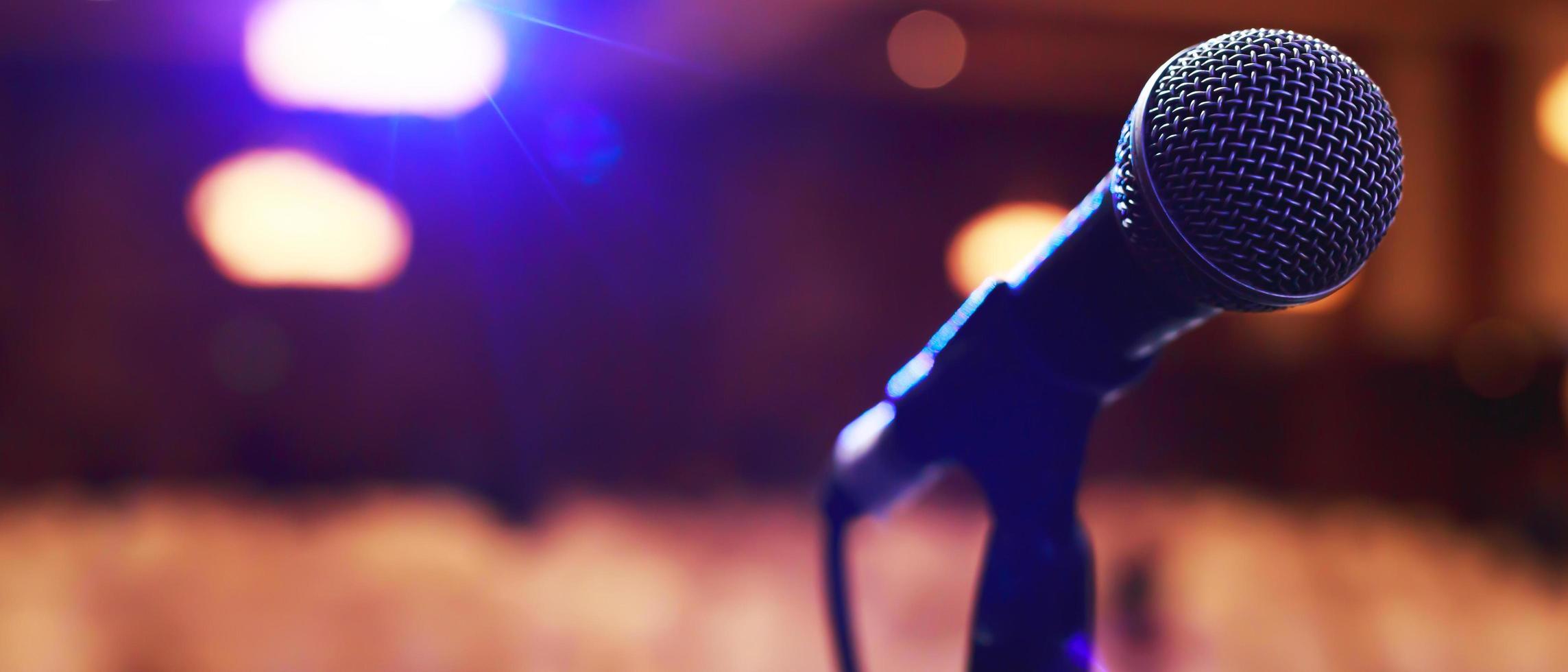 Close up of microphone on stage lighting at concert hall or conference room. copy space banner. soft focus. photo