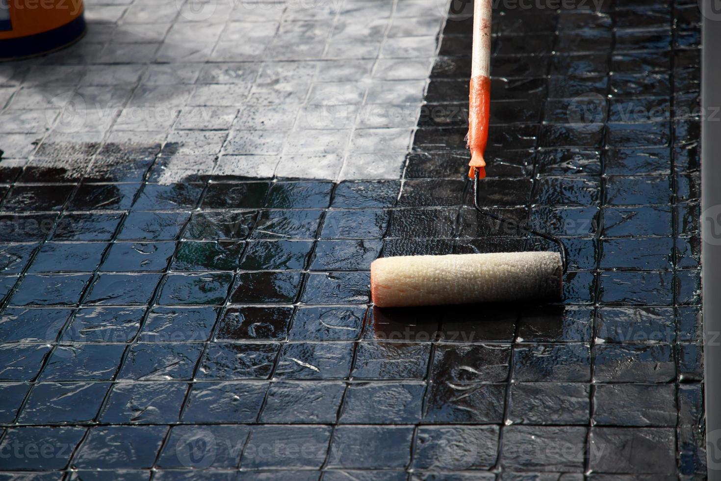 Painter of black printed concrete stamps outside the building photo