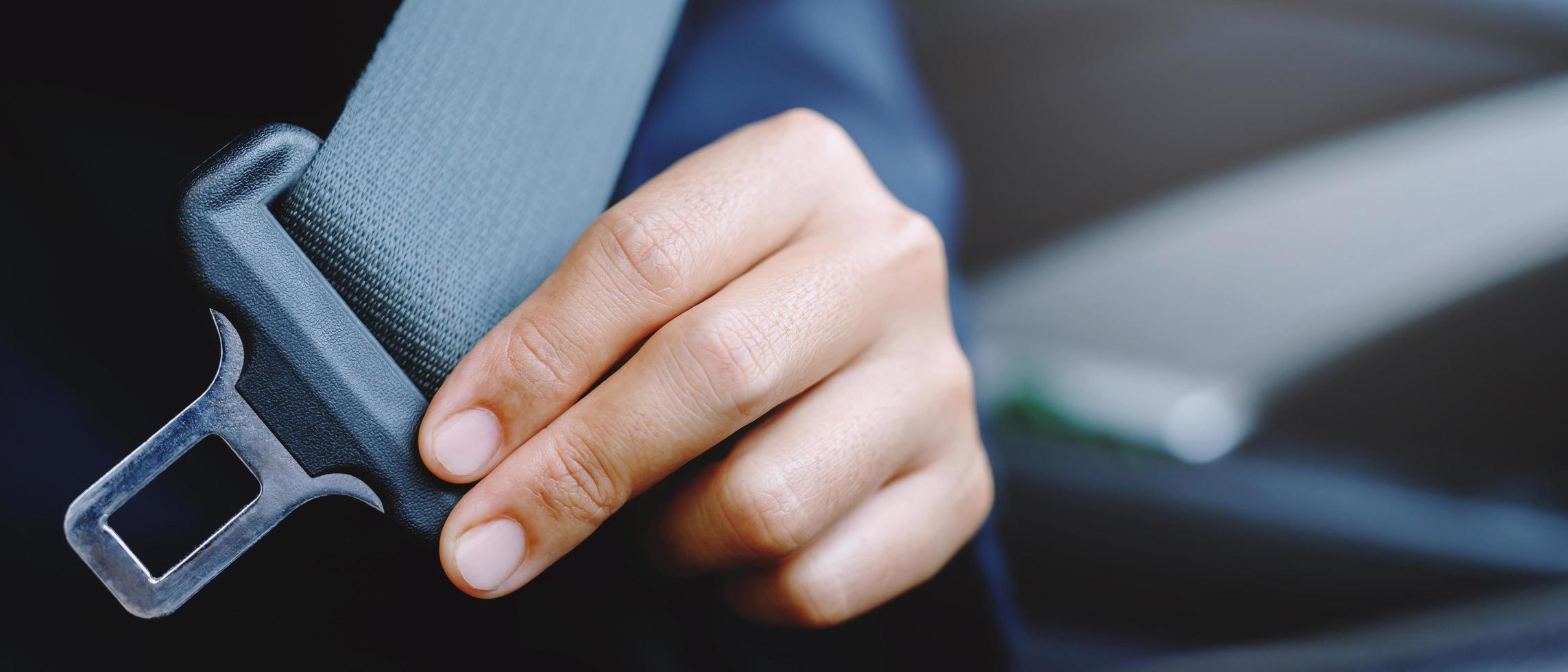 primer plano de la mujer que sujeta a mano el cinturón de seguridad del asiento en el coche por seguridad antes de conducir por la carretera. concepto de viaje de transporte. enfoque suave. foto