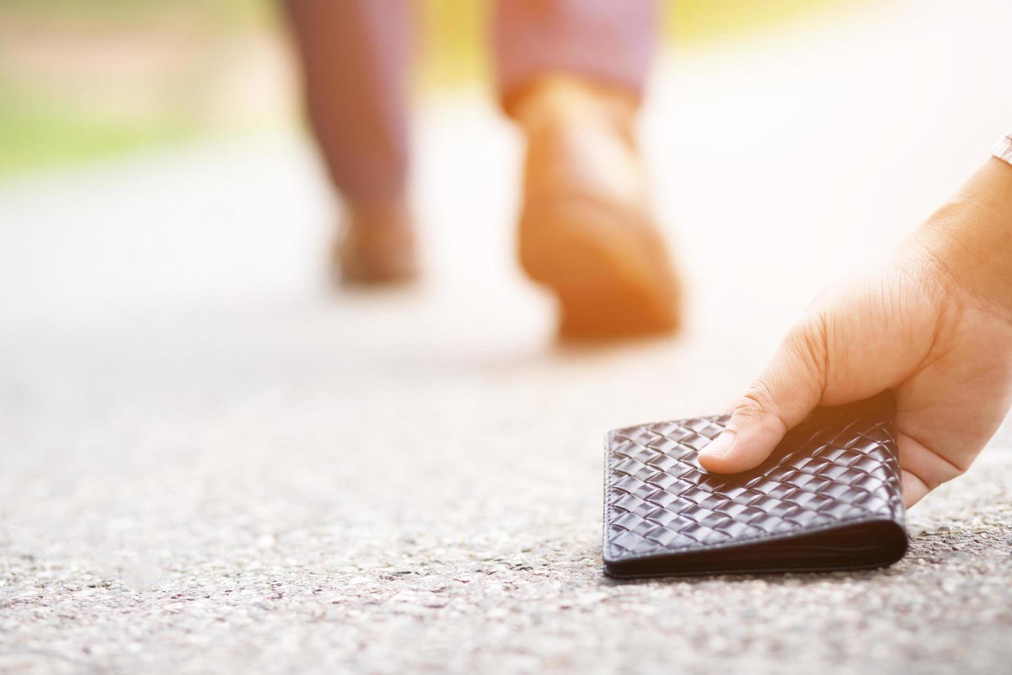 businessman had lost leather wallet with money on the street. Close-up of wallet lying on the sidewalk in during the trip to work. photo