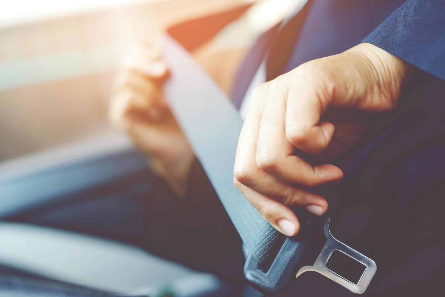 Close Up of people woman hand fastening seat safety belt in car for safety before driving on the road. concept transport travel. soft focus. photo