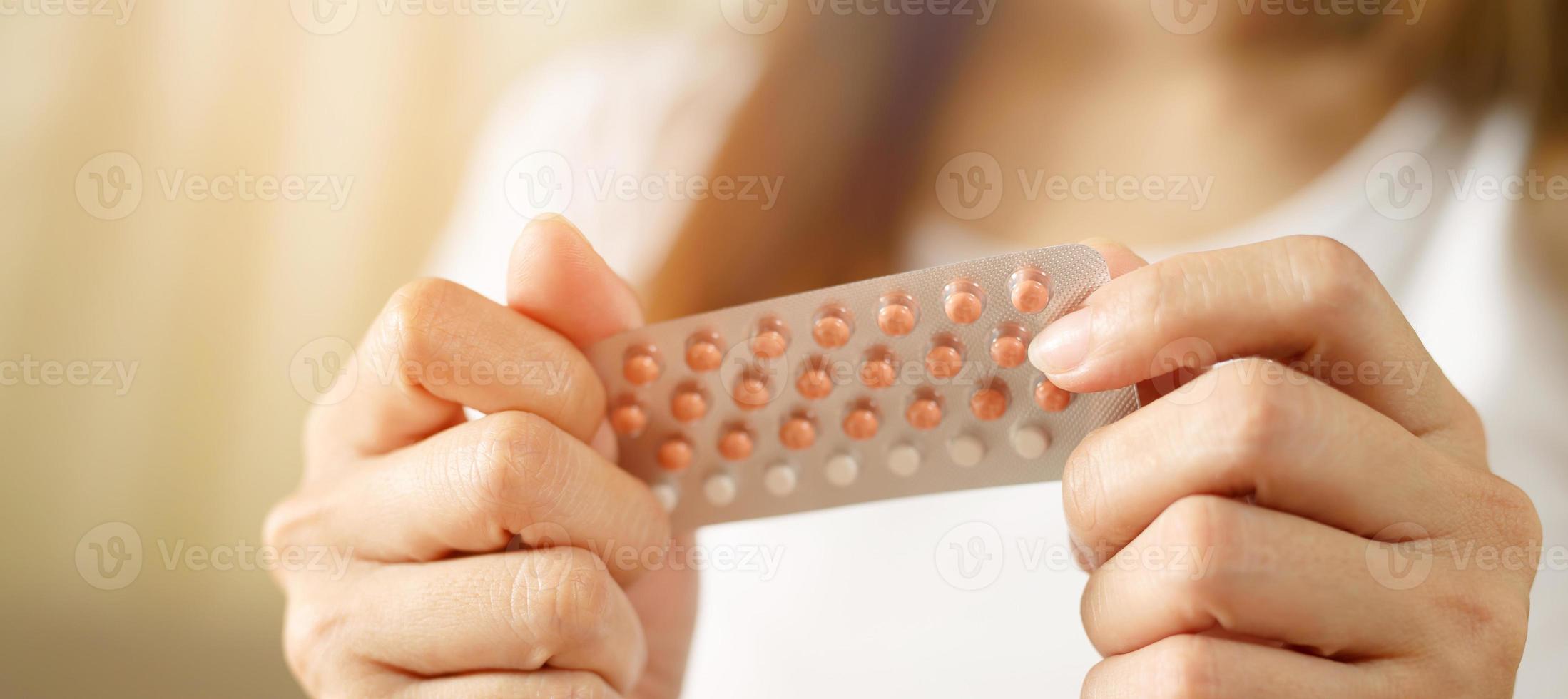 Woman hands opening birth control pills in hand. eating Contraceptive pill. Contraception reduces childbirth and pregnancy concept. Leave space to write descriptive text. photo