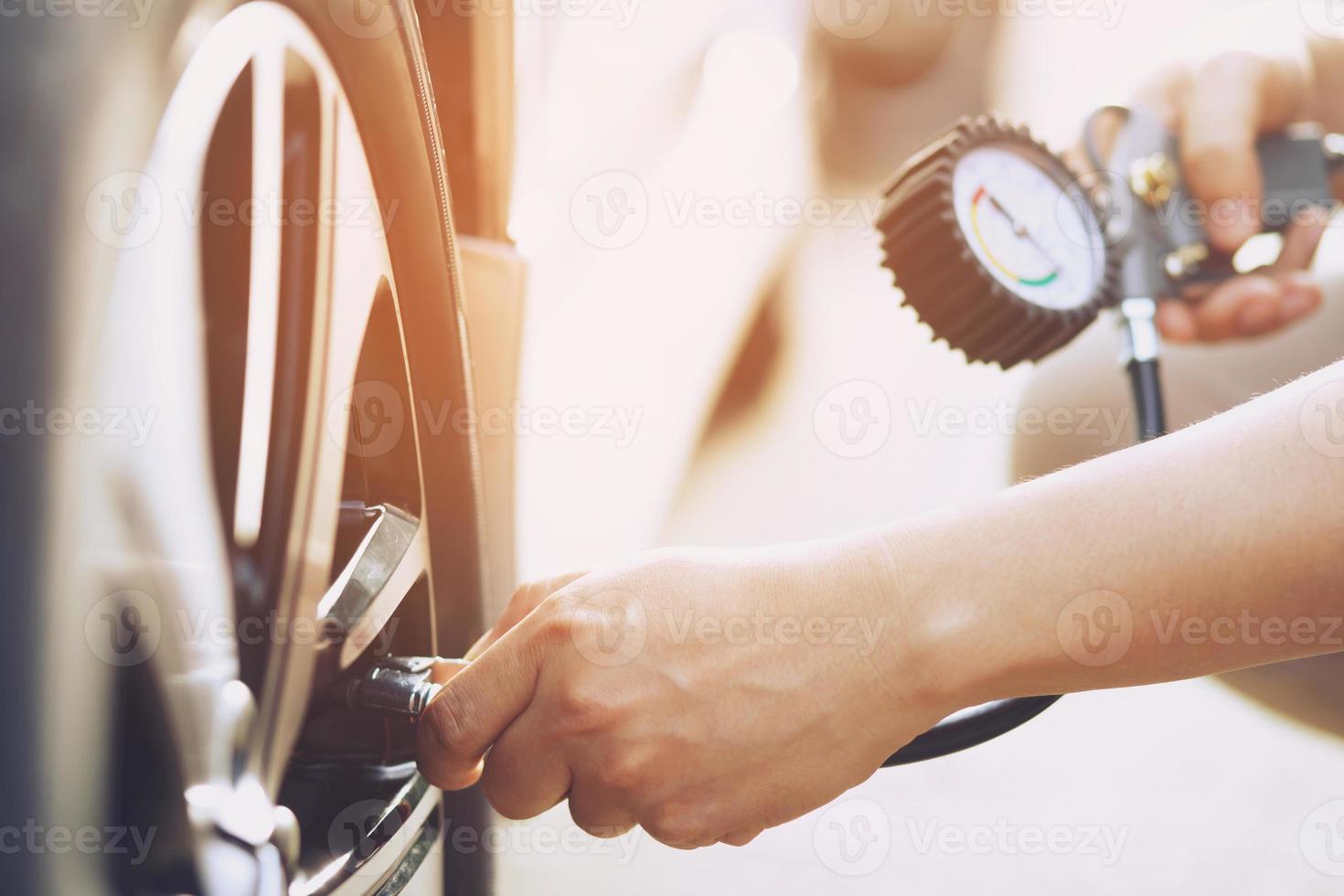 close up hand man car parking a check and inflate the tire fill up the air for safe driving on the go. Transportation travel vehicle concept. photo