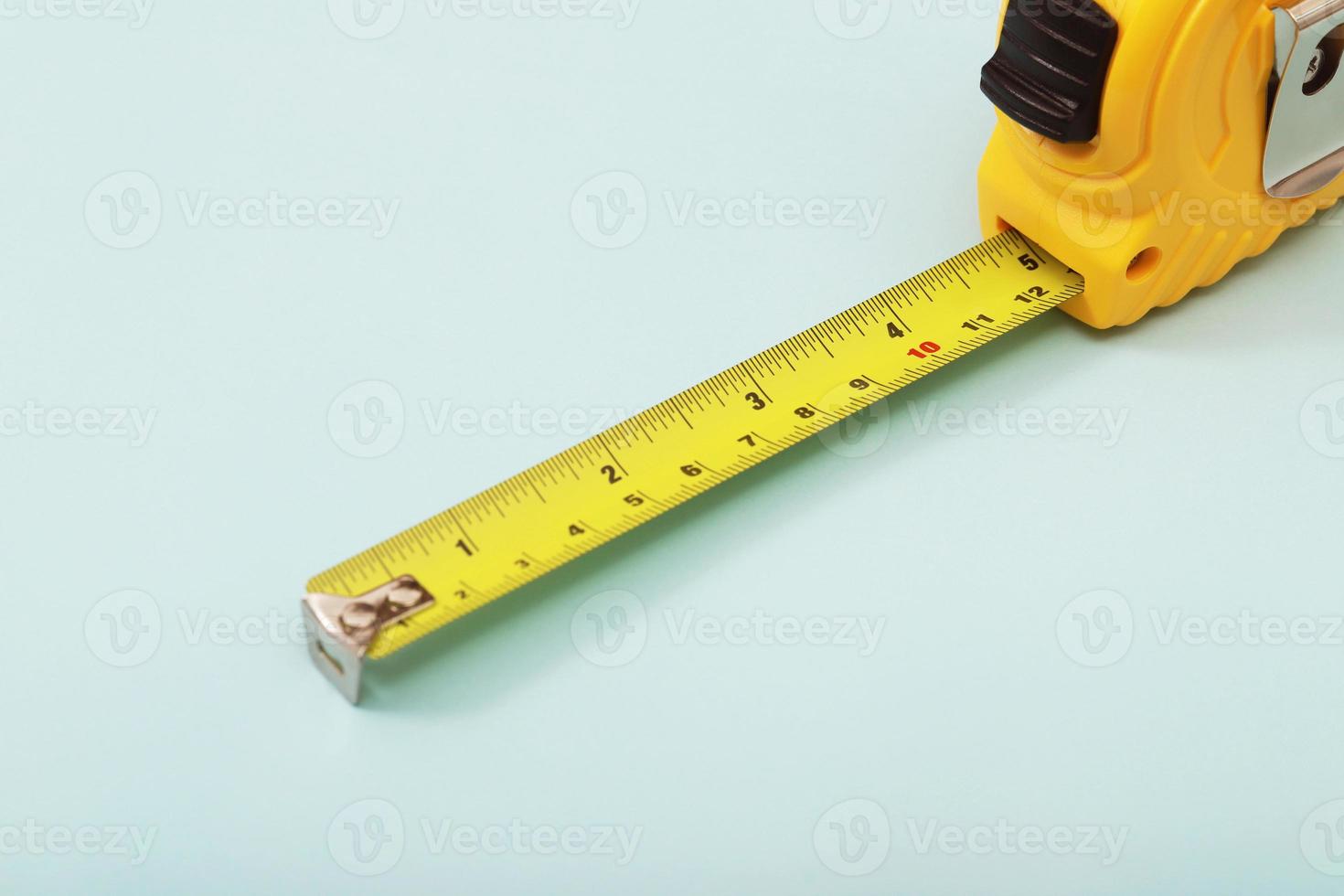The yellow measuring tape for the mason is placed on a blue background. Soft focus. photo