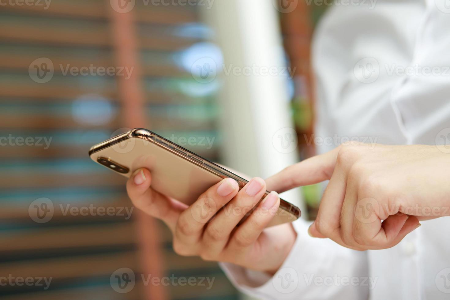 cierre la mano de una mujer joven para ver un mensaje en un teléfono inteligente móvil durante el descanso. usando teléfonos celulares para comunicarse en el mundo en línea. con pantalla negra en blanco o vacía foto