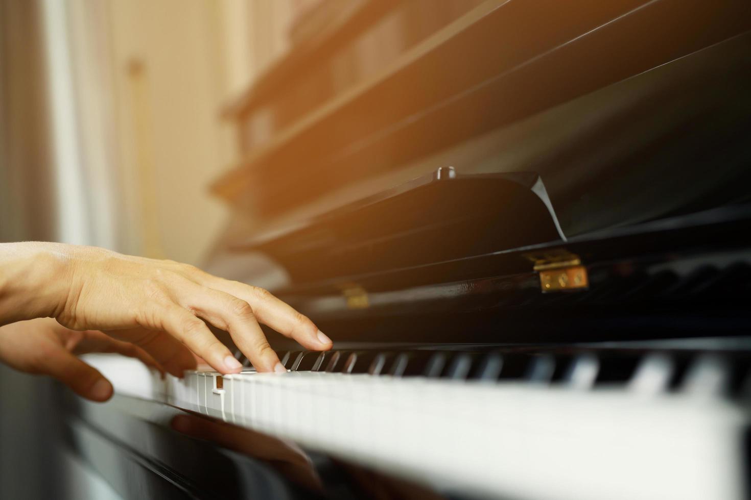 close up of hand people man musician playing piano keyboard with selective focus keys. can be used as a background. photo