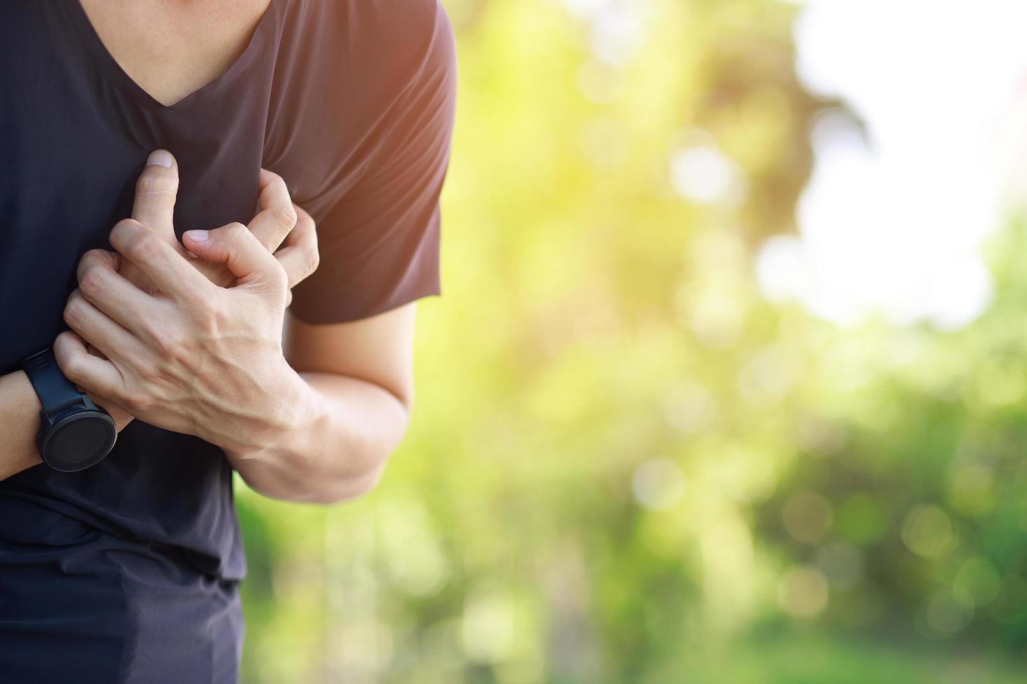 hombre con dolor de pecho - ataque al corazón al aire libre. o el ejercicio pesado hace que el cuerpo sufra enfermedades del corazón foto