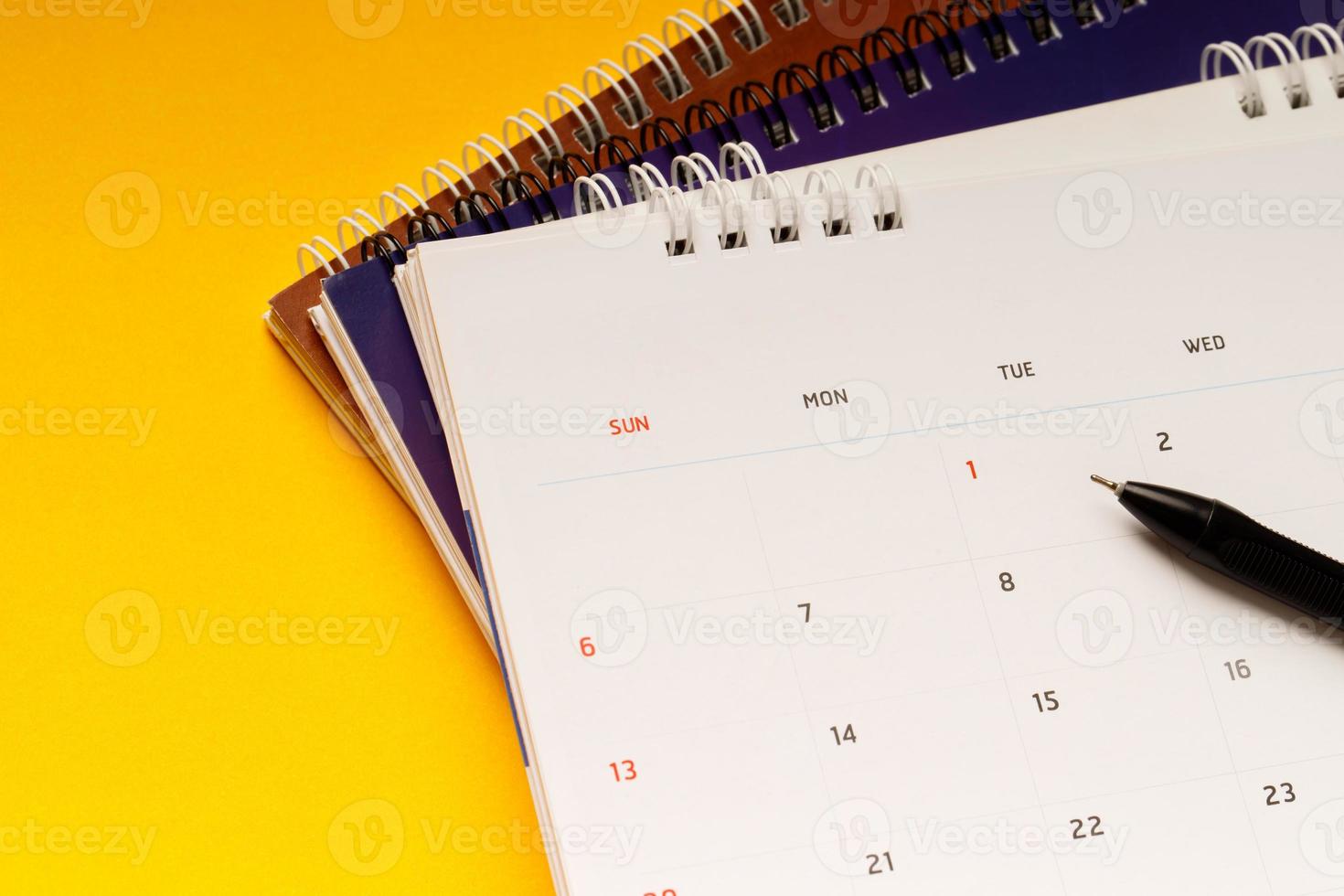 close up top view calendar schedule to make appointment meeting or manage timetable each day lay on yellow background for planning work and travel concept. photo