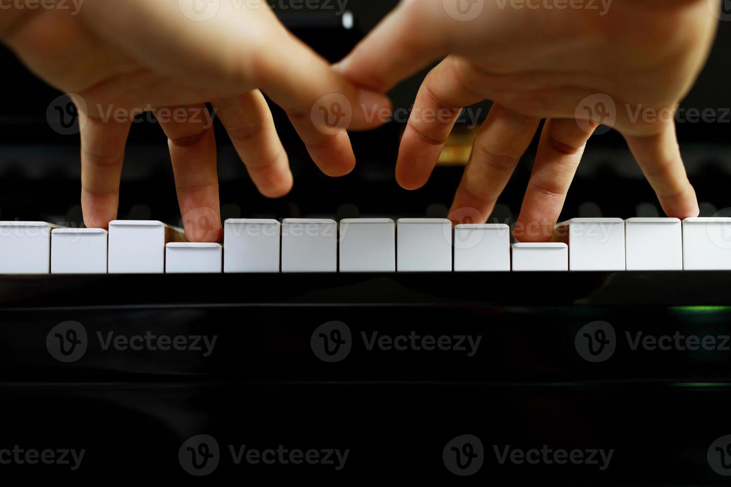 close up of hand people man musician playing piano keyboard with selective focus keys. can be used as a background. photo