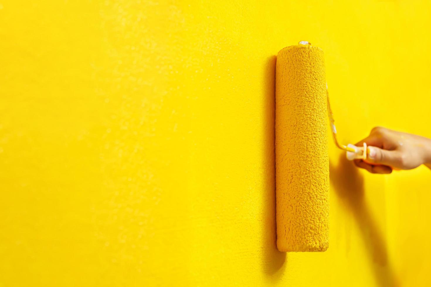 Painter is painting the interior wall yellow photo