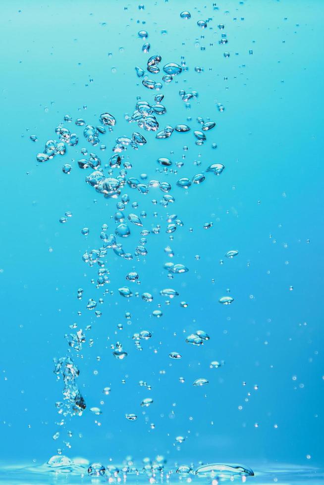 Abstract background image of bubbles in water. Clean water with water droplets and waves. Fresh water a glass with bubbles blue background. photo