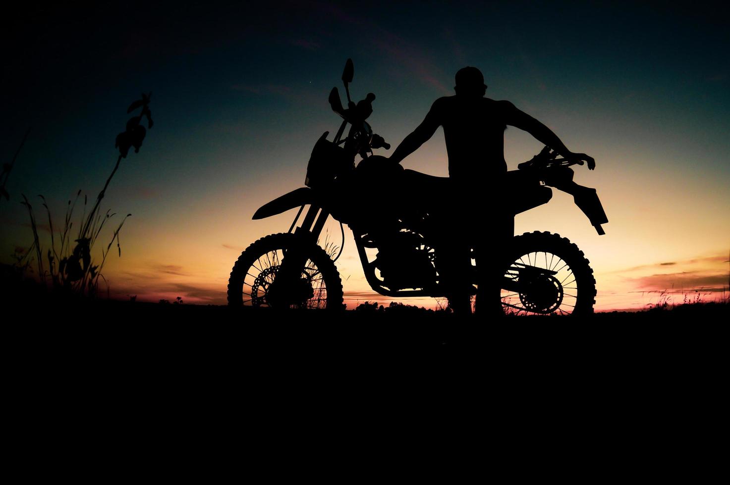 Men's silhouettes and touring motocross bikes. Park to relax in the mountains in the evening. adventure travel and leisure concept photo