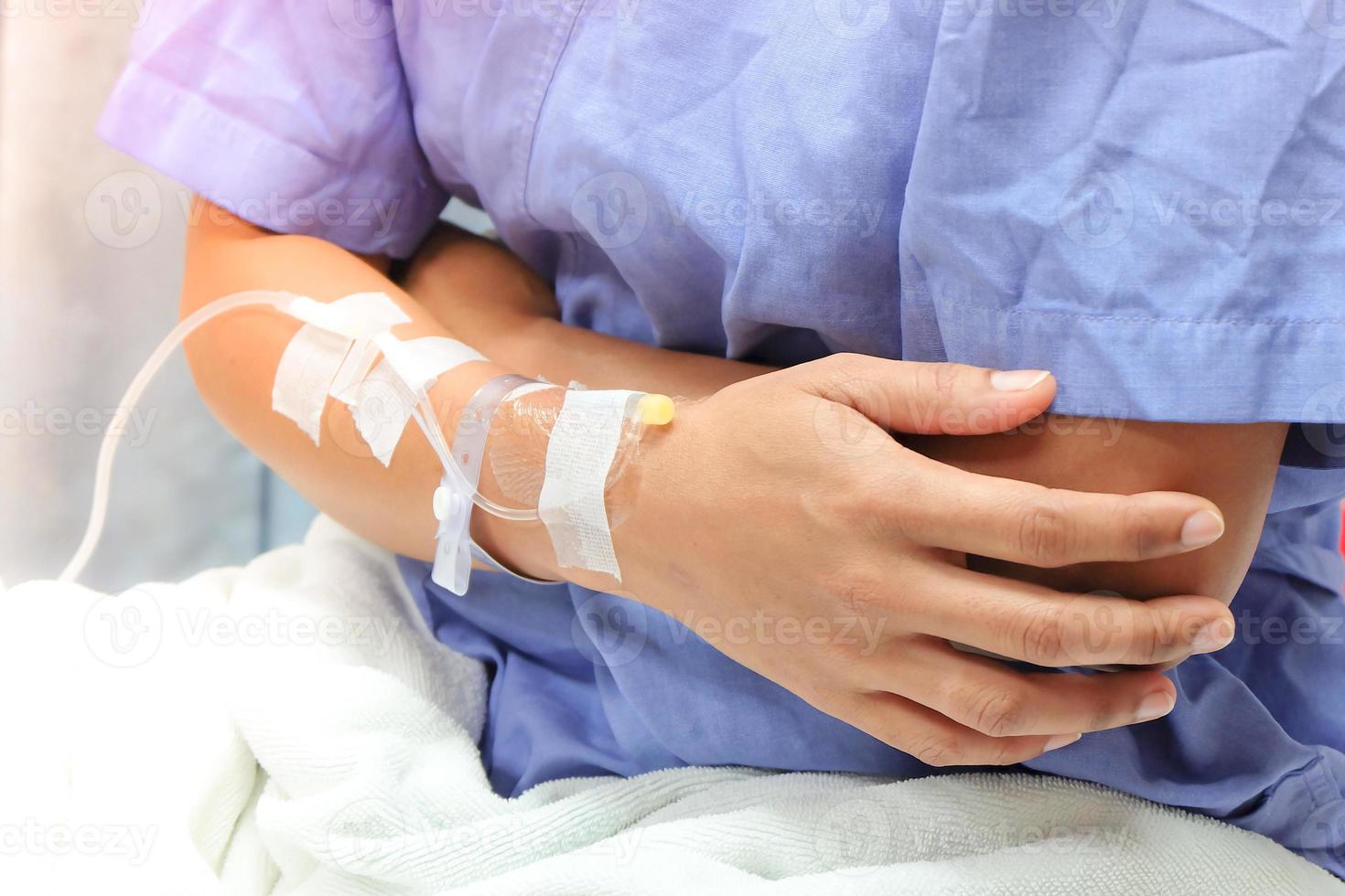 Close up of saline drip in patient's hand . Asian woman with  hospital admission. photo