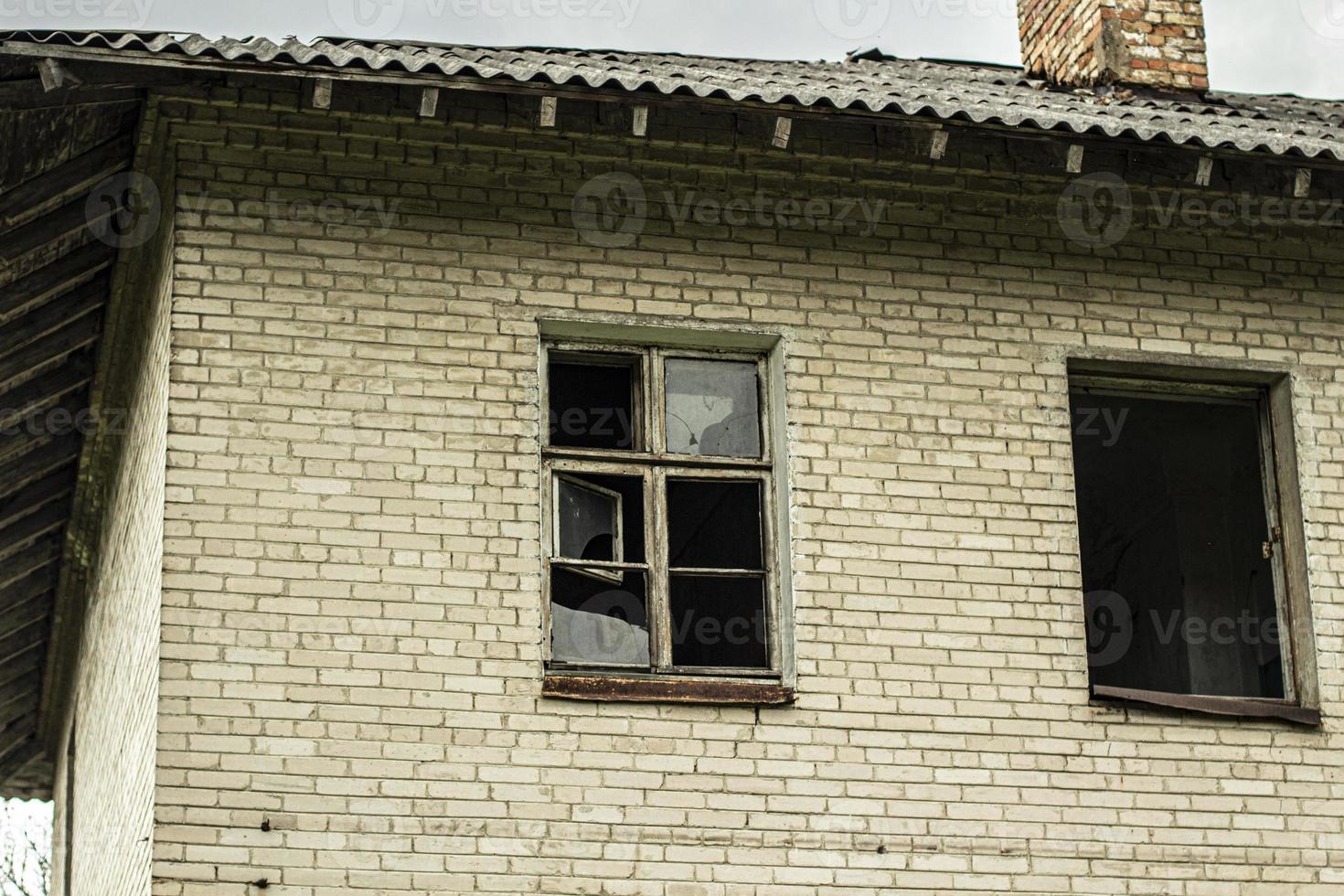 An abandoned house with broken windows. Old building in the city. photo