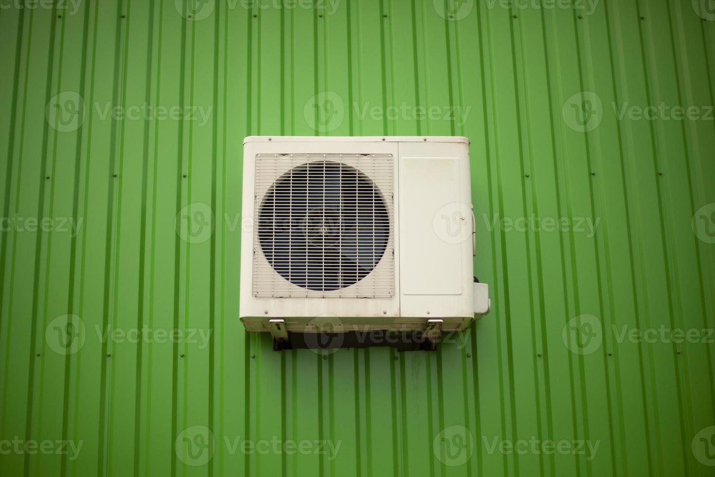 aire acondicionado en la pared verde del edificio. equipo de refrigeración en el trabajo. foto