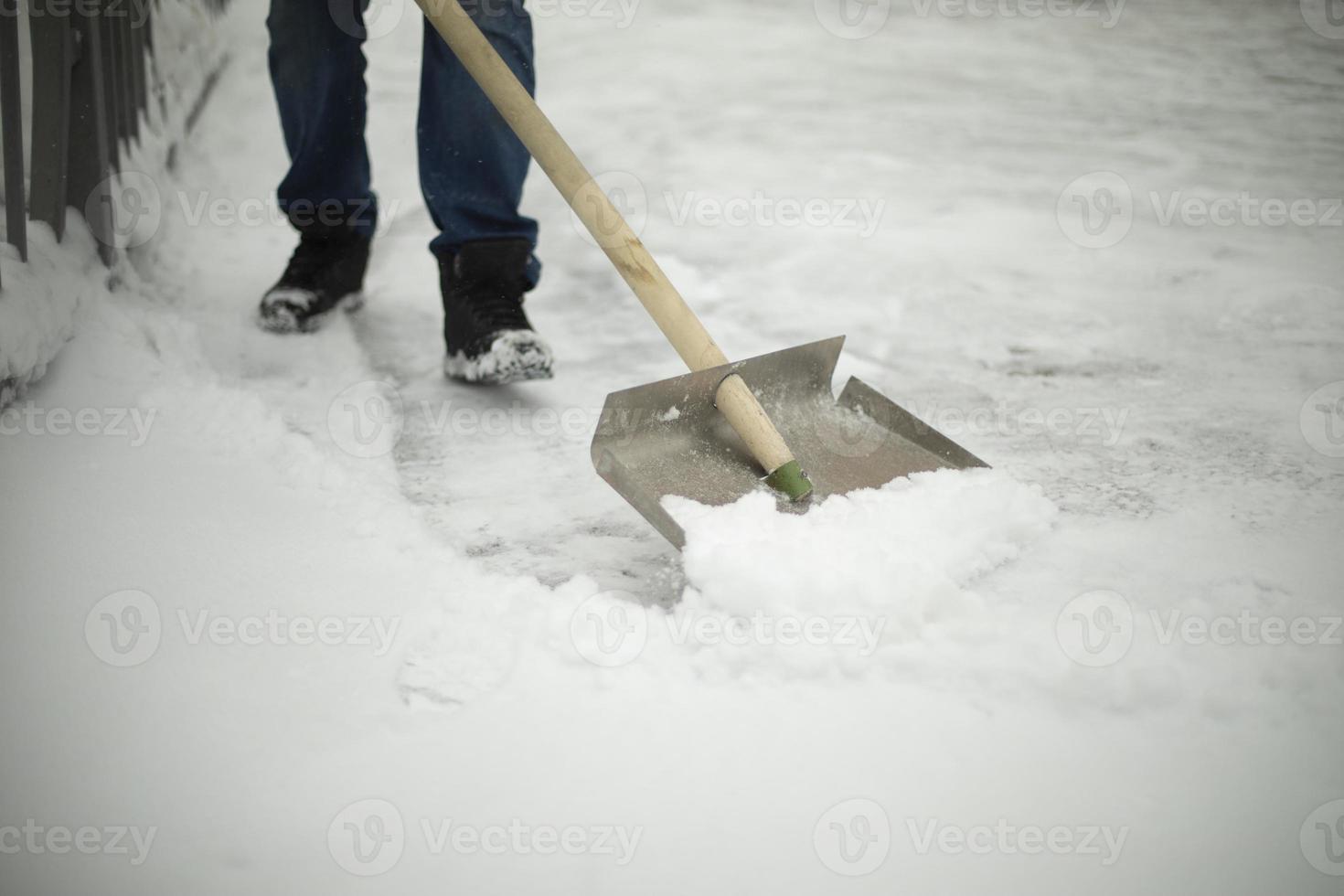 Shovel snow removal. Tool for cleaning snowdrift. Janitor cleans road from precipitation. photo