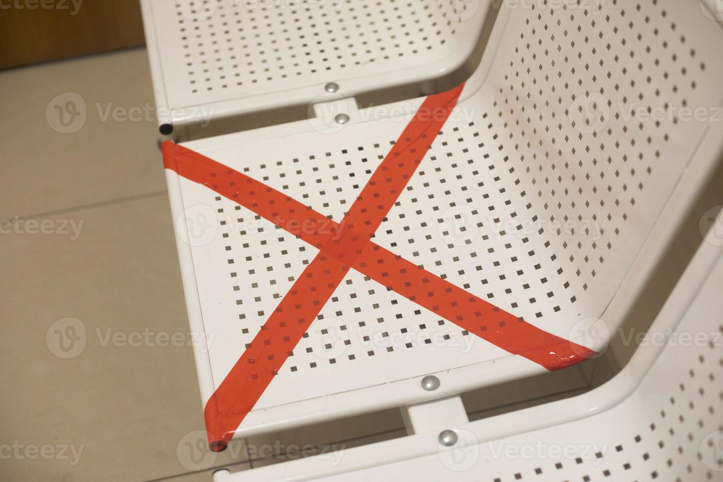 Red cross on the seat. The place is not available. Restriction of places due to quarantine. Prohibition of close distance. photo