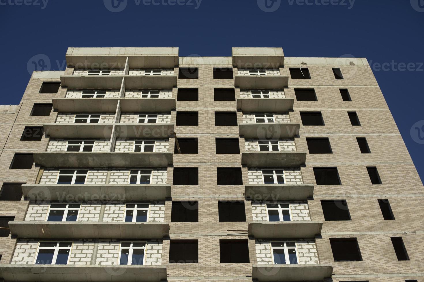 Building under construction in the city. The windows are not fully inserted into the wall of the house. photo