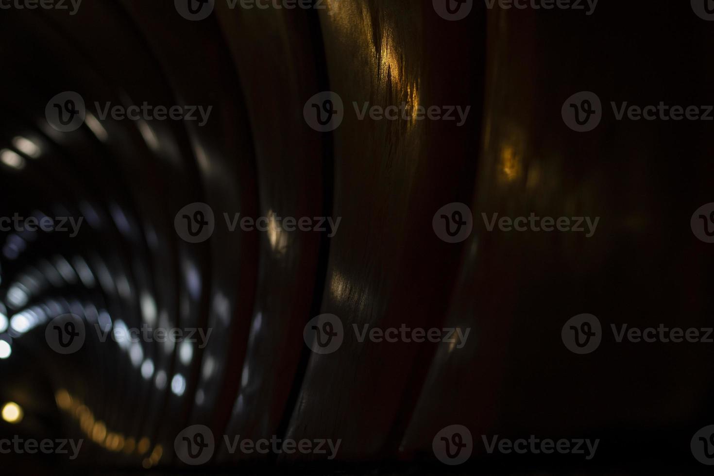 Reflection of dim light in a sparkling transparent surface. The game of reflections of electric light in the tunnel. photo