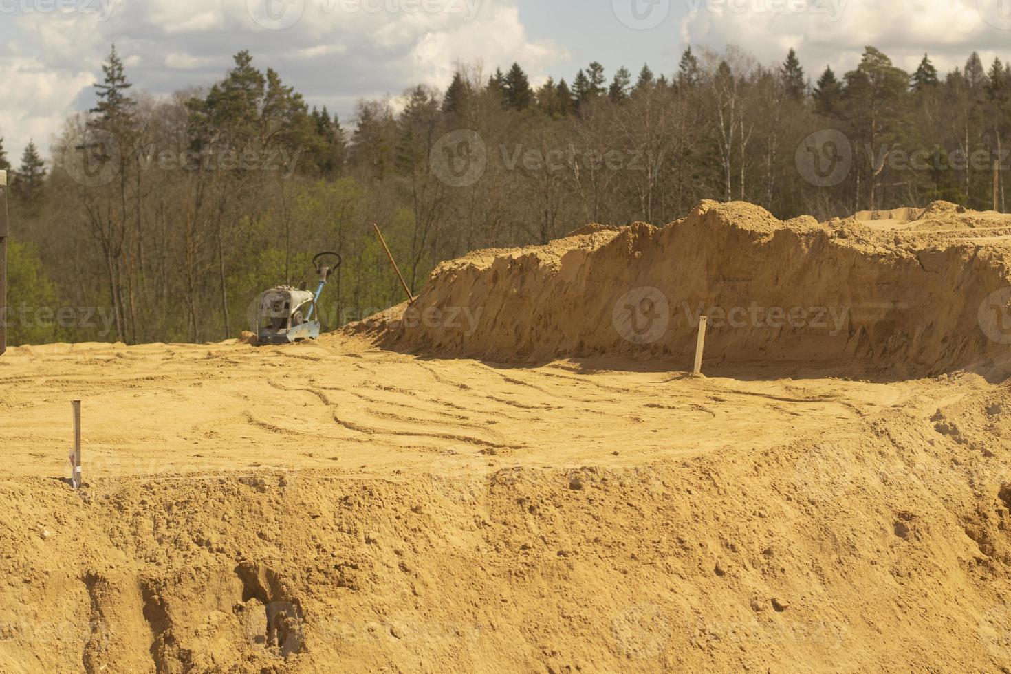 Sand platform. Laying sand in the base. A lot of building material. photo