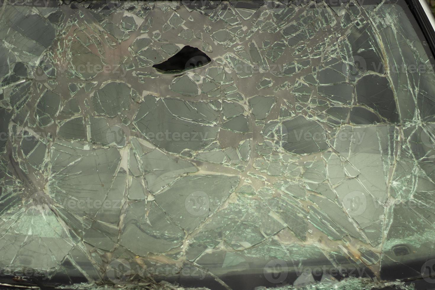 Broken glass in detail. Car windshield after the accident. Lots of small pieces. photo