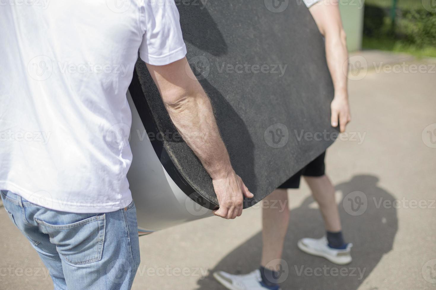 The movers are dragging the table. Men carry the burden. photo