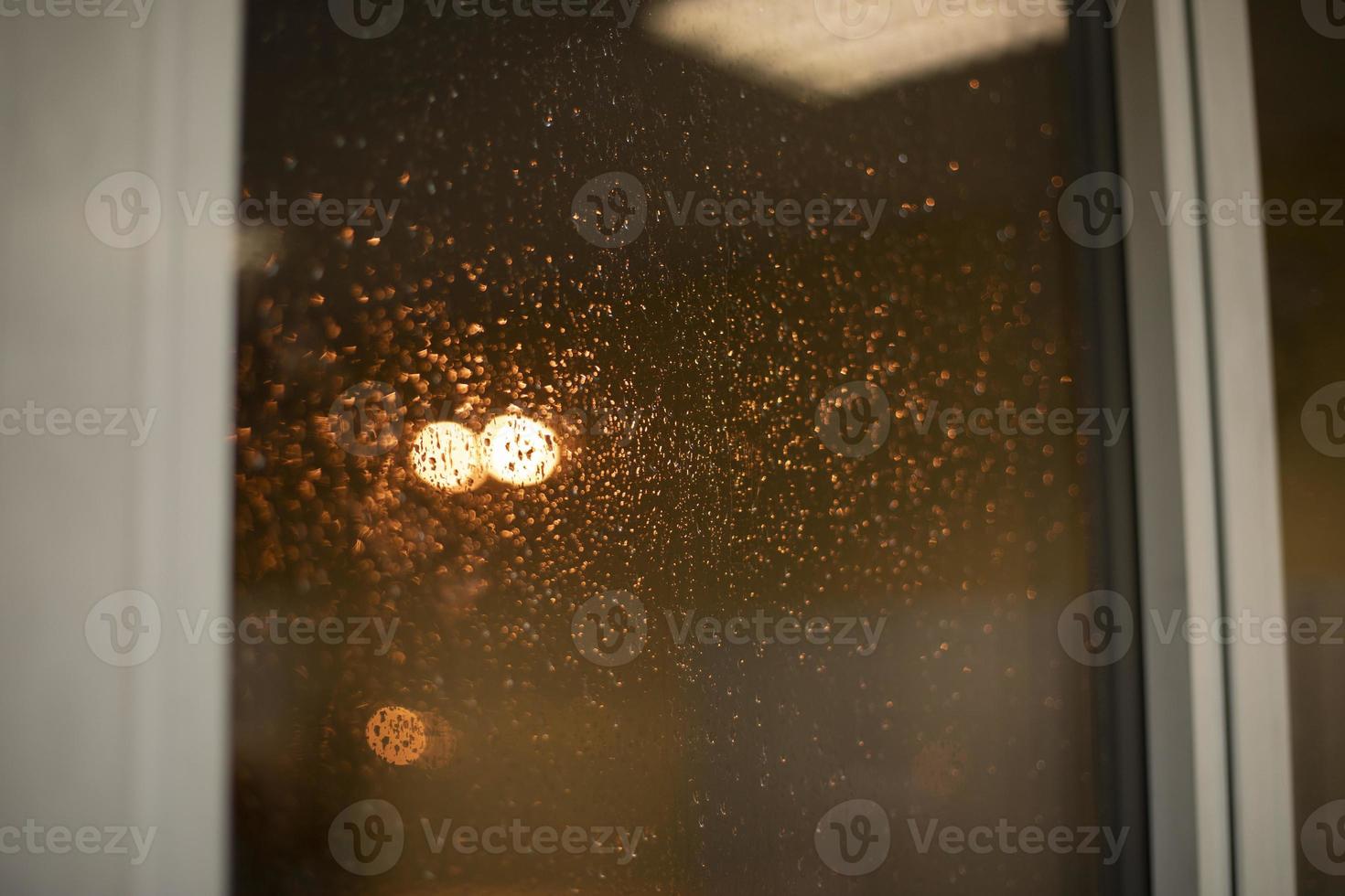 Wet glass. Drops on the window. Light rain outside the window. photo