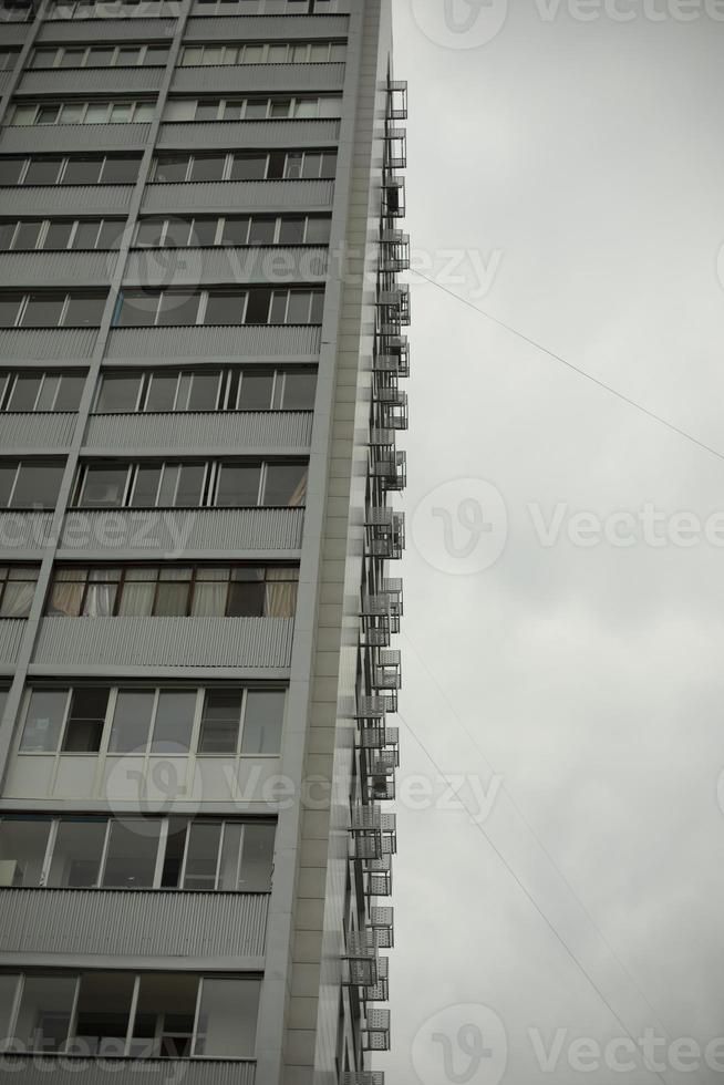 Tall building with windows and balconies. Urban development in the 21st century. Architecture of the 20th century in the Soviet Union. photo