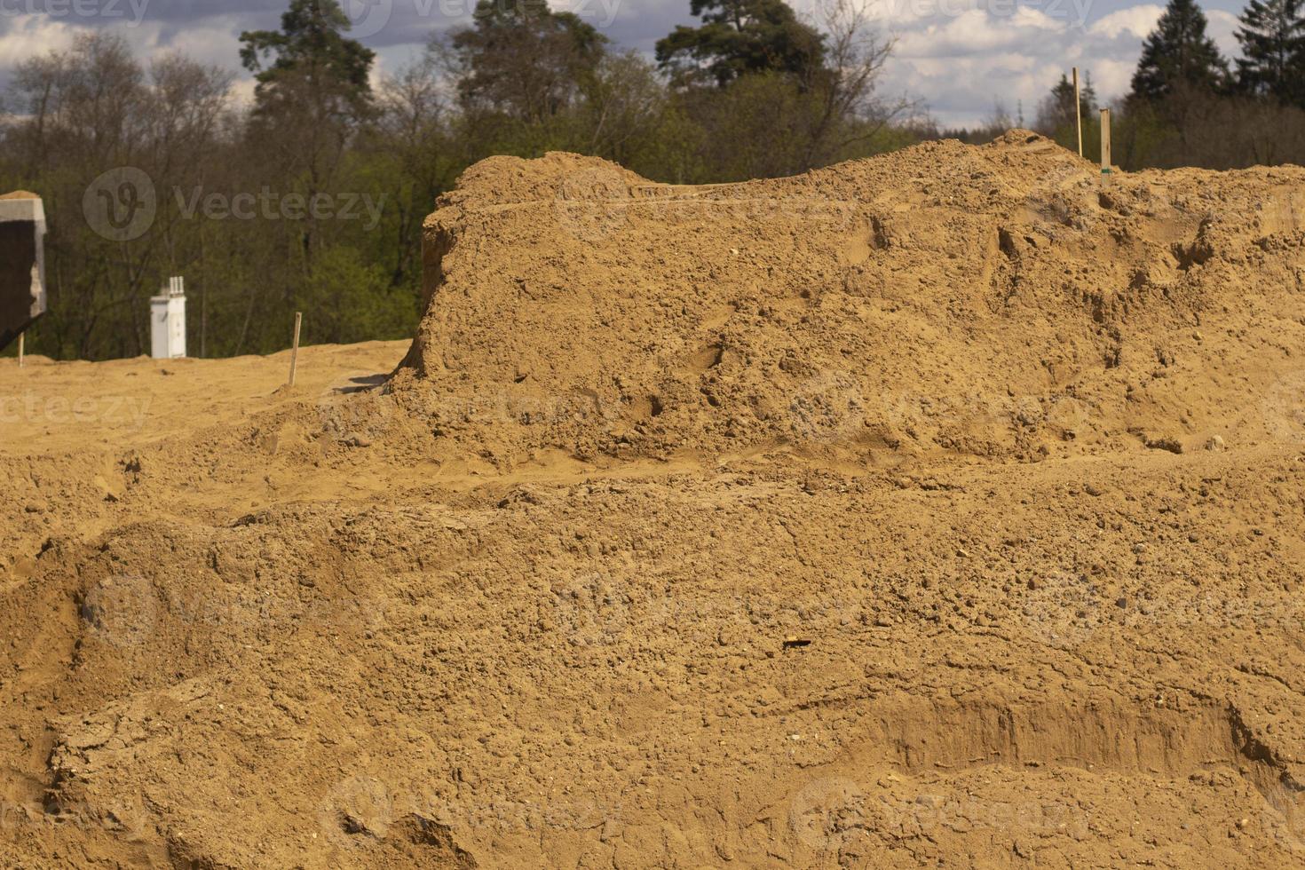 Sand platform. Laying sand in the base. A lot of building material. photo