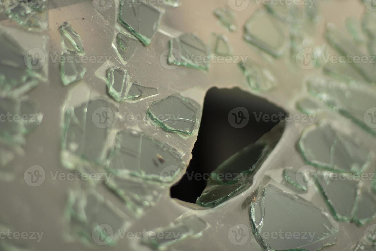 Broken glass in detail. Car windshield after the accident. Lots of small pieces. photo