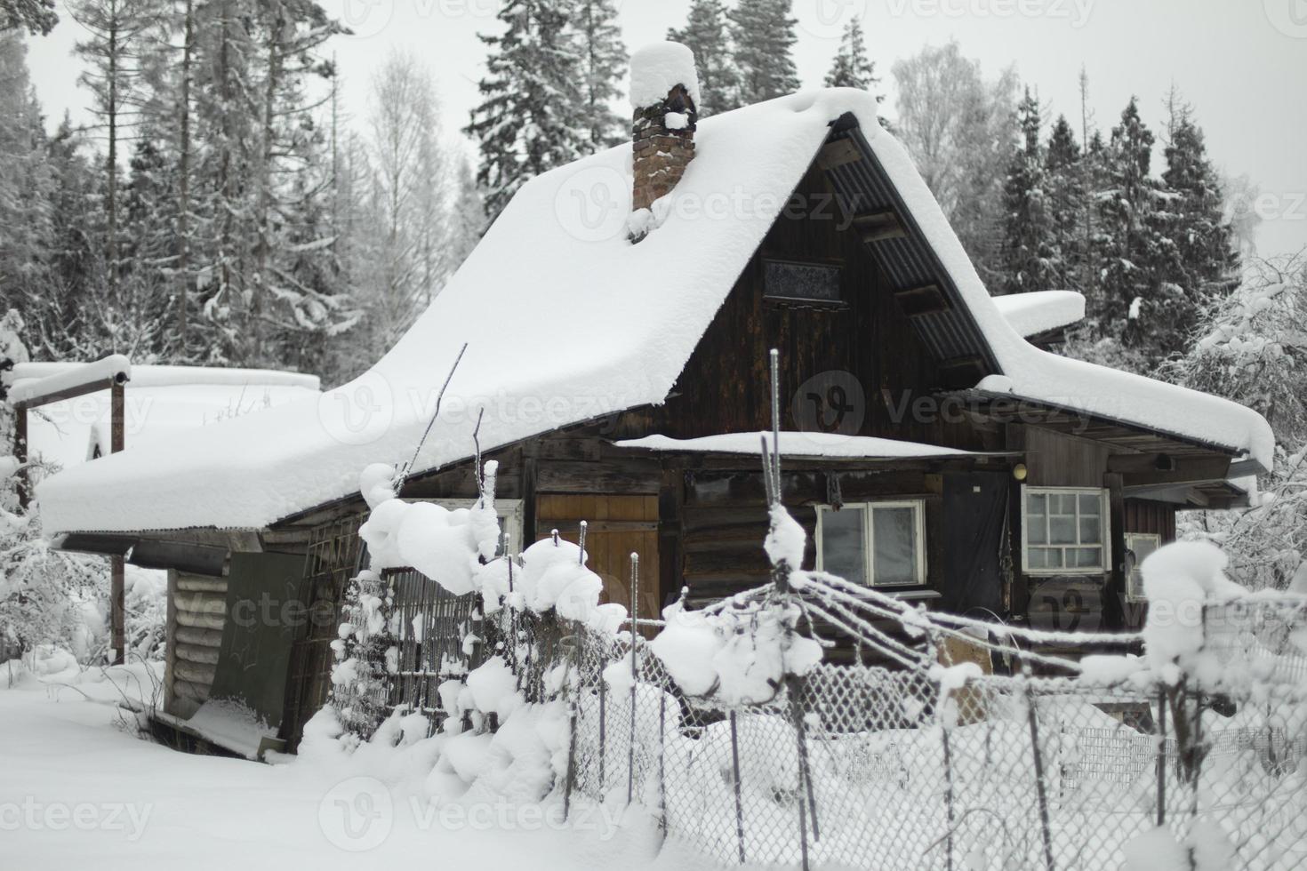 Country house in winter. Roof is in snow. Countryside. photo