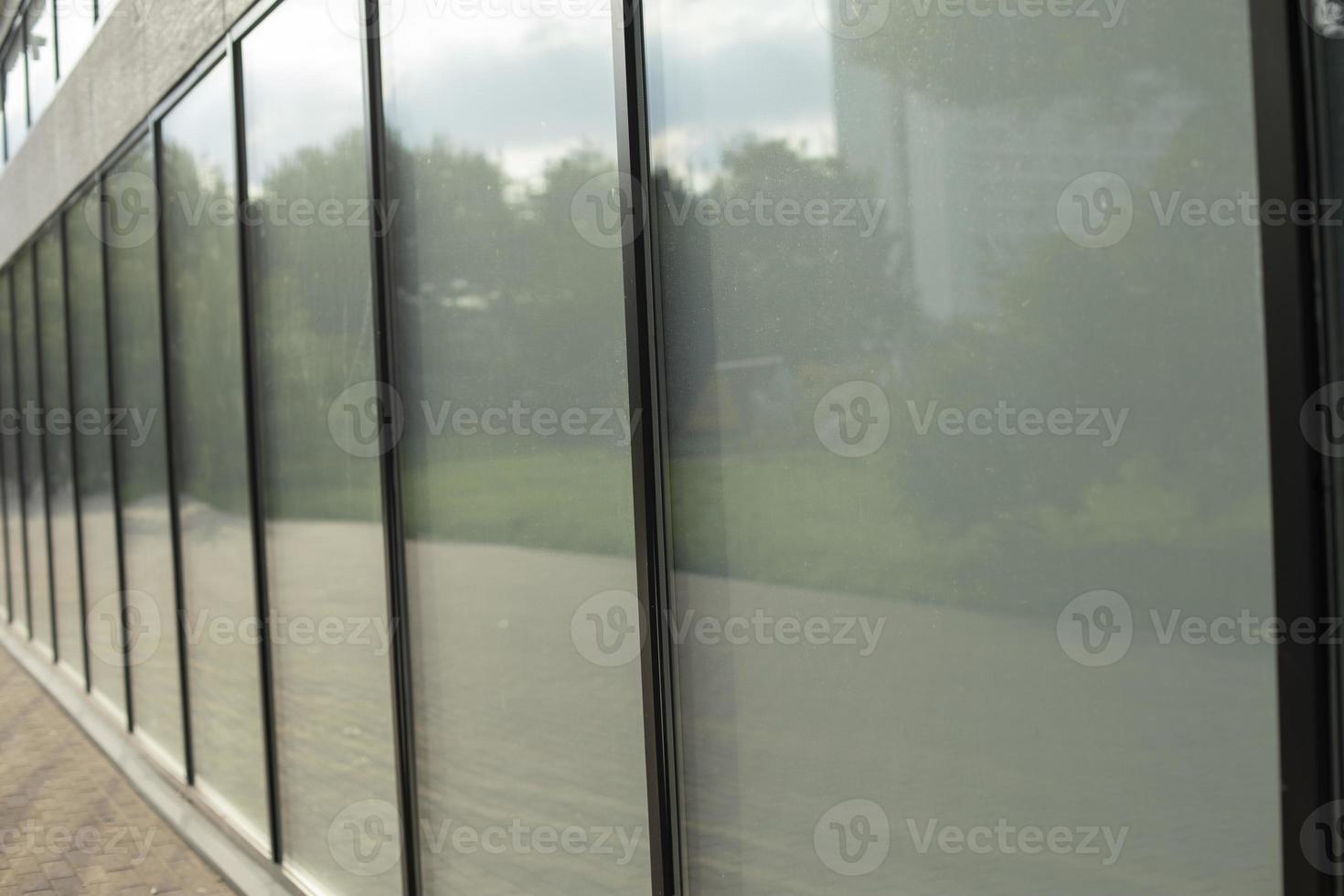 Facade glass in a long house. A row of window frames. photo