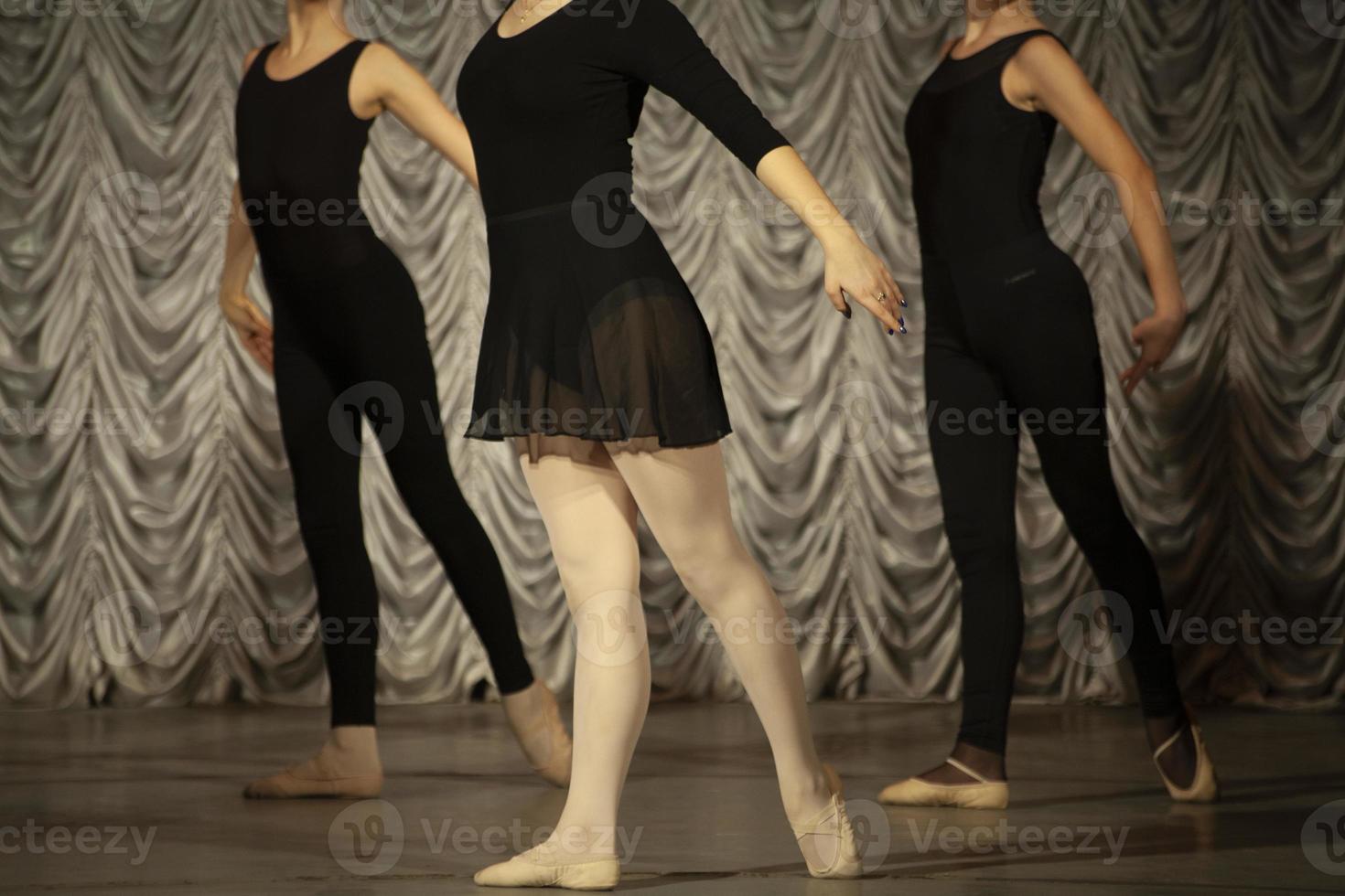 The girls rehearse the dance. Ballerinas in class. A girl in a black dress. photo