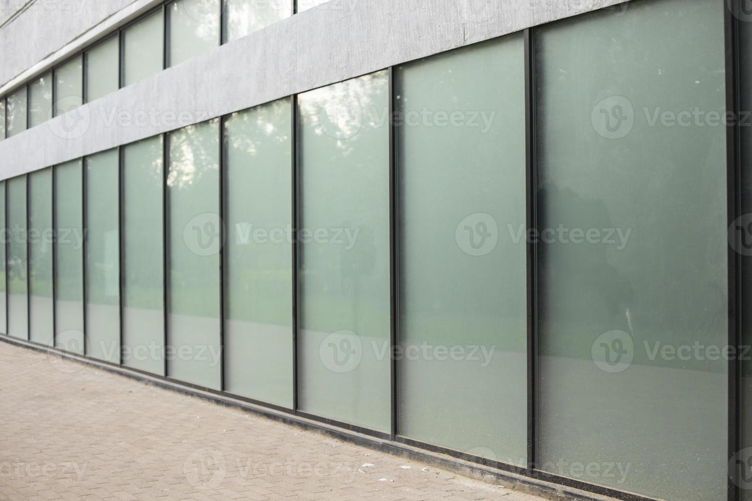 Facade glass in a long house. A row of window frames. photo