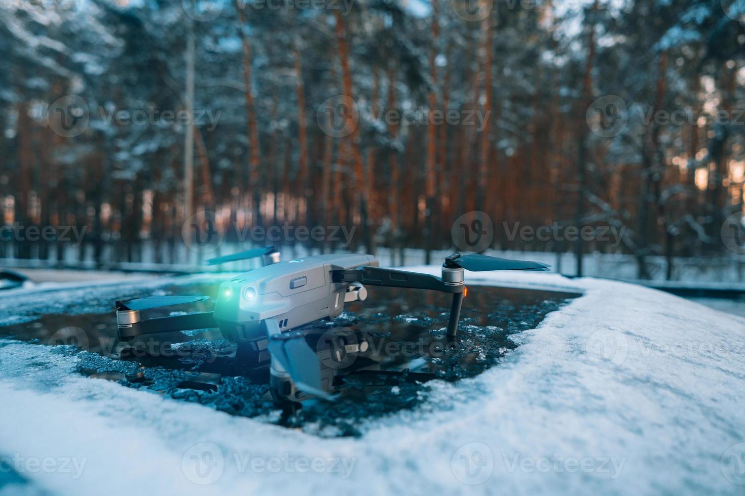 Drone standing on the roof of a snow-covered car photo