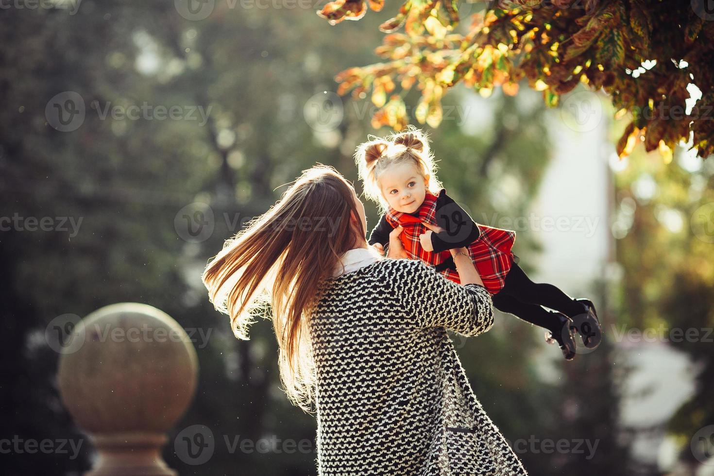 Mother and little daughter playing in a park photo