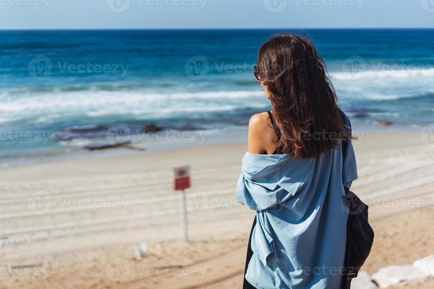 Young beautiful girl looks afar at sea photo