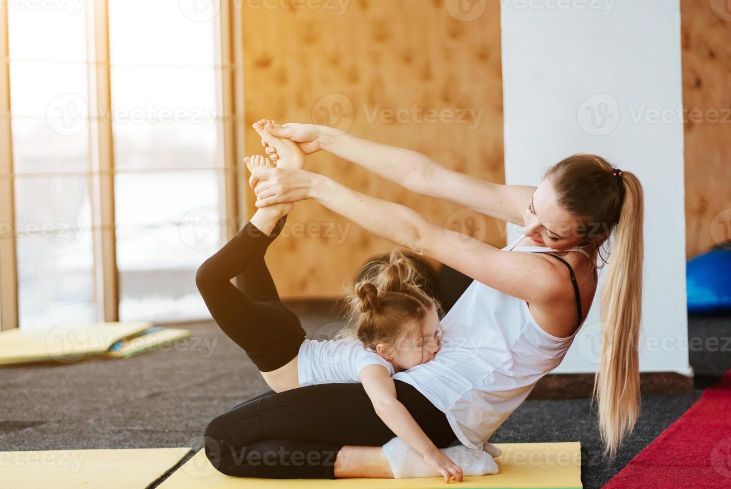 Mom and daughter together perform different exercises photo