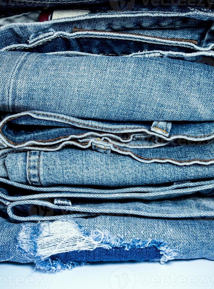 Pile of blue jeans, fabric texture photo