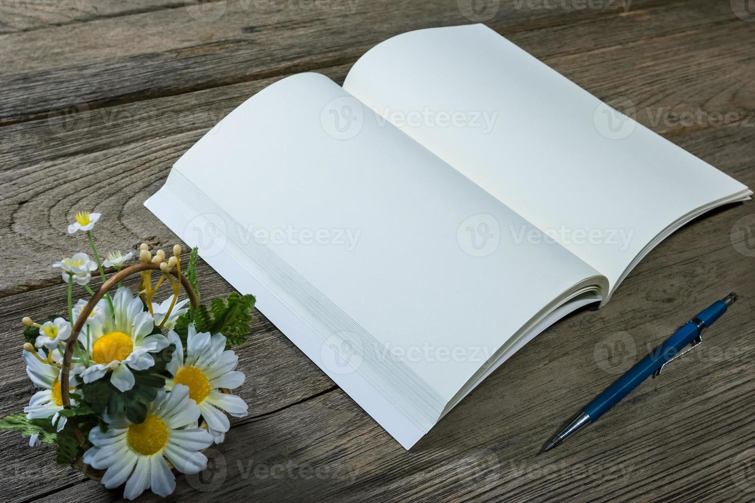 open note book with clutch-type pencil on wood background photo