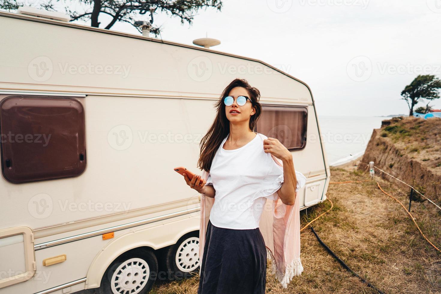 Beautiful, young girl posing on a wild beach sailor at the van photo