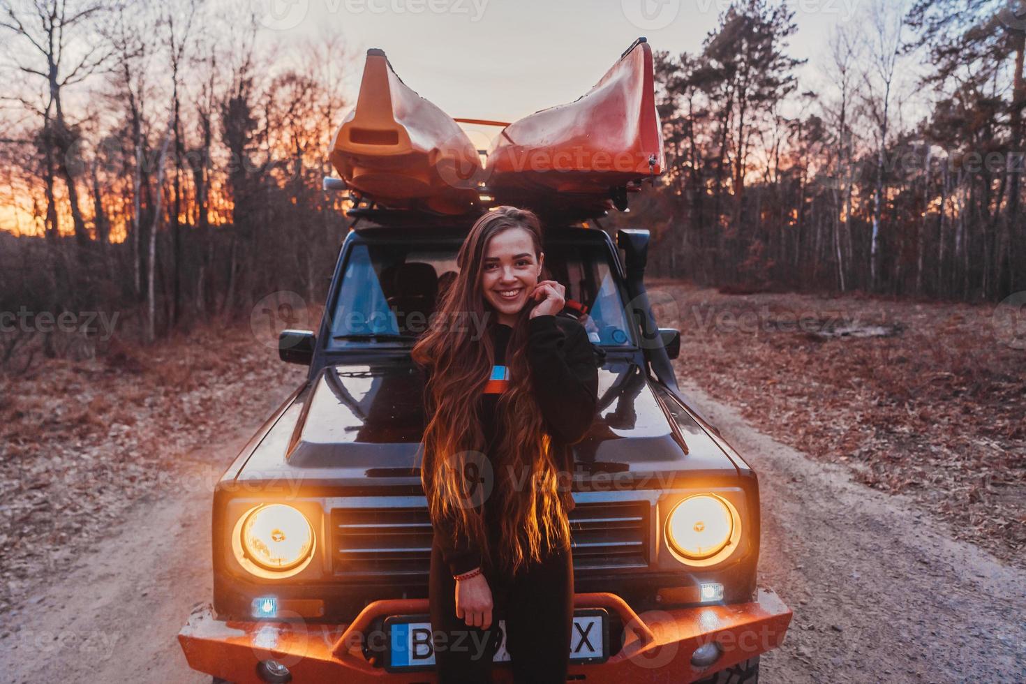 Woman stands front off 4x4 terrain vehicle. photo