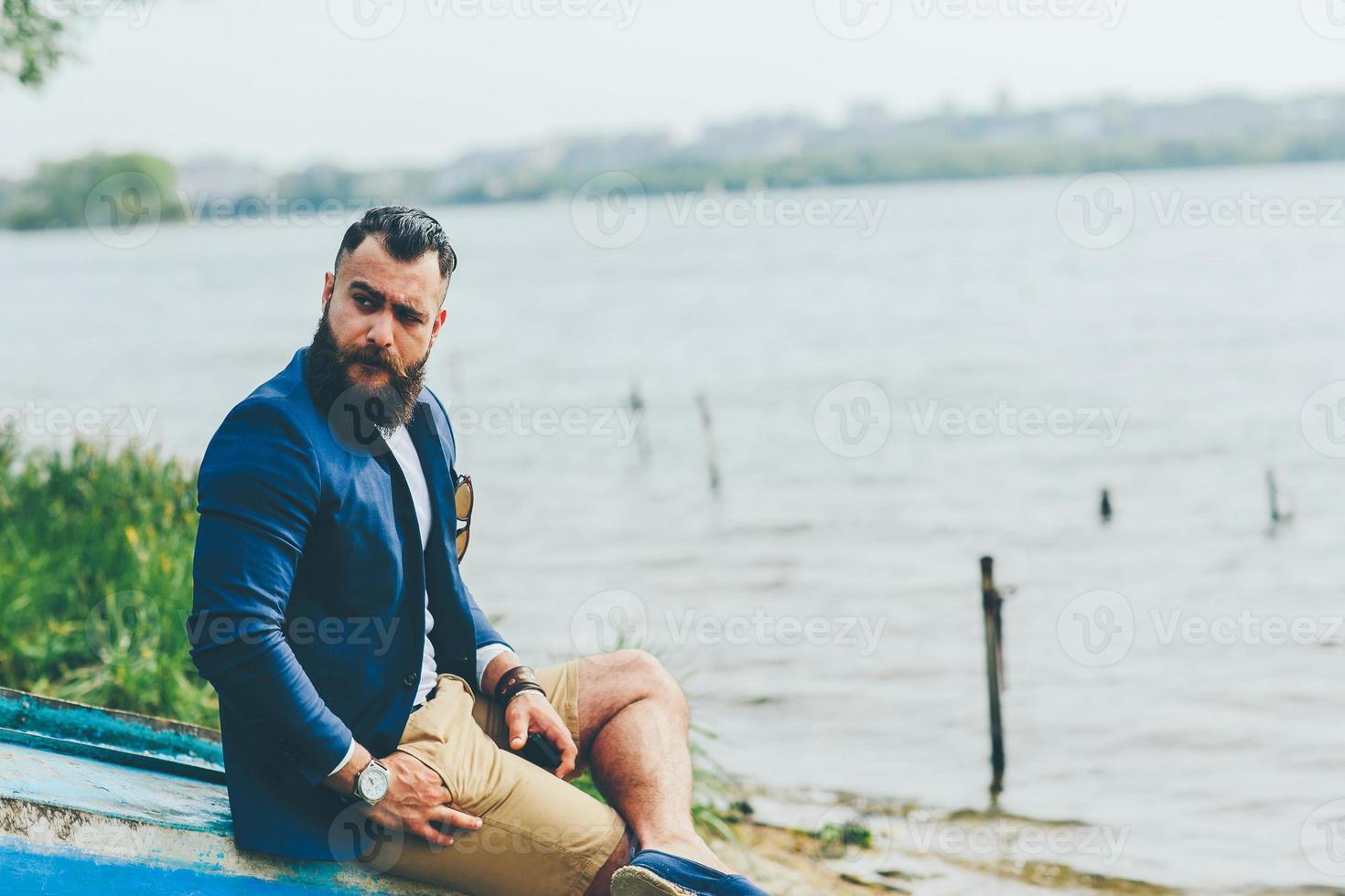 hombre barbudo americano mira a la orilla del río foto