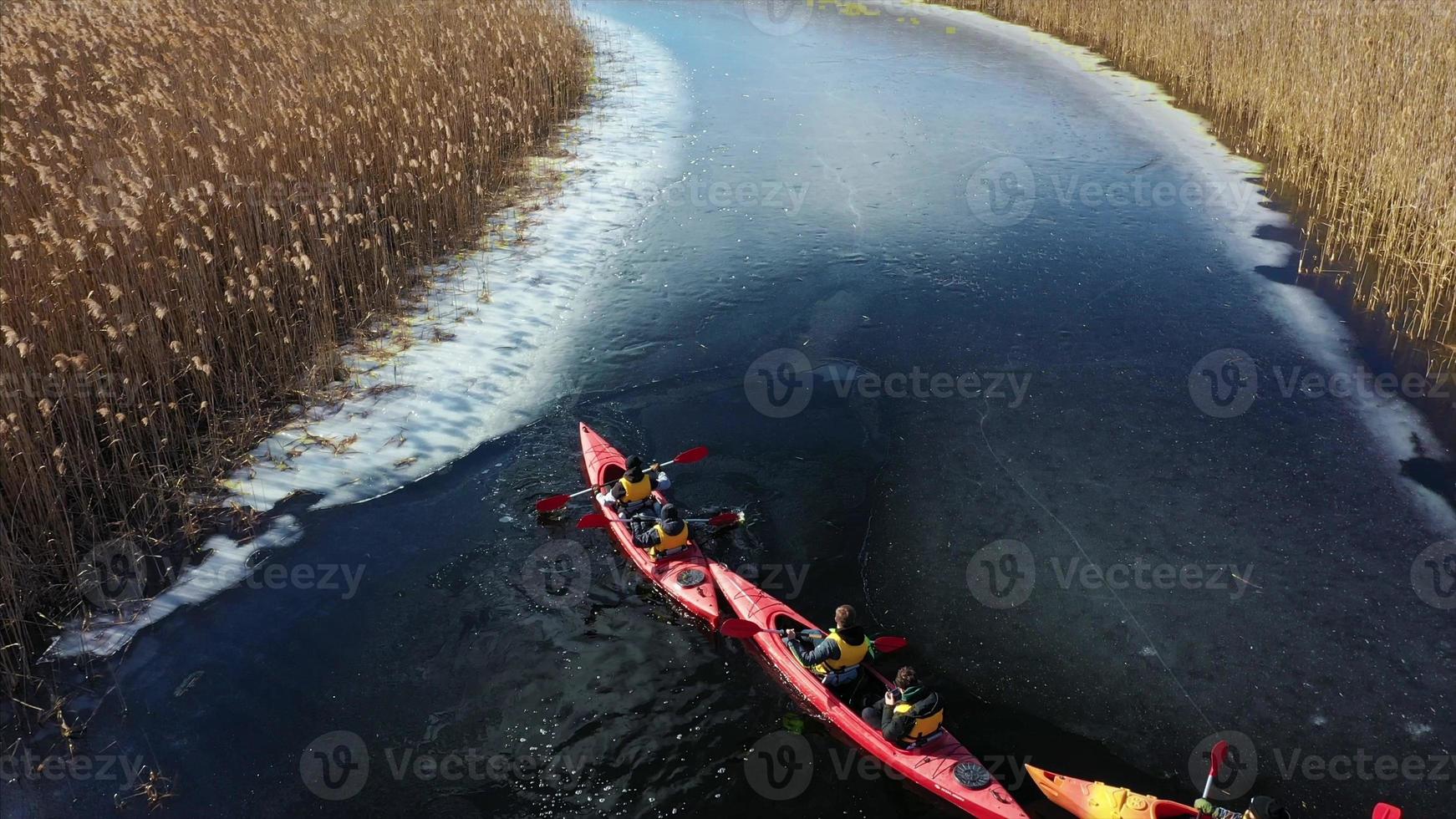 Group of people in kayaks among reeds on the autumn river. photo