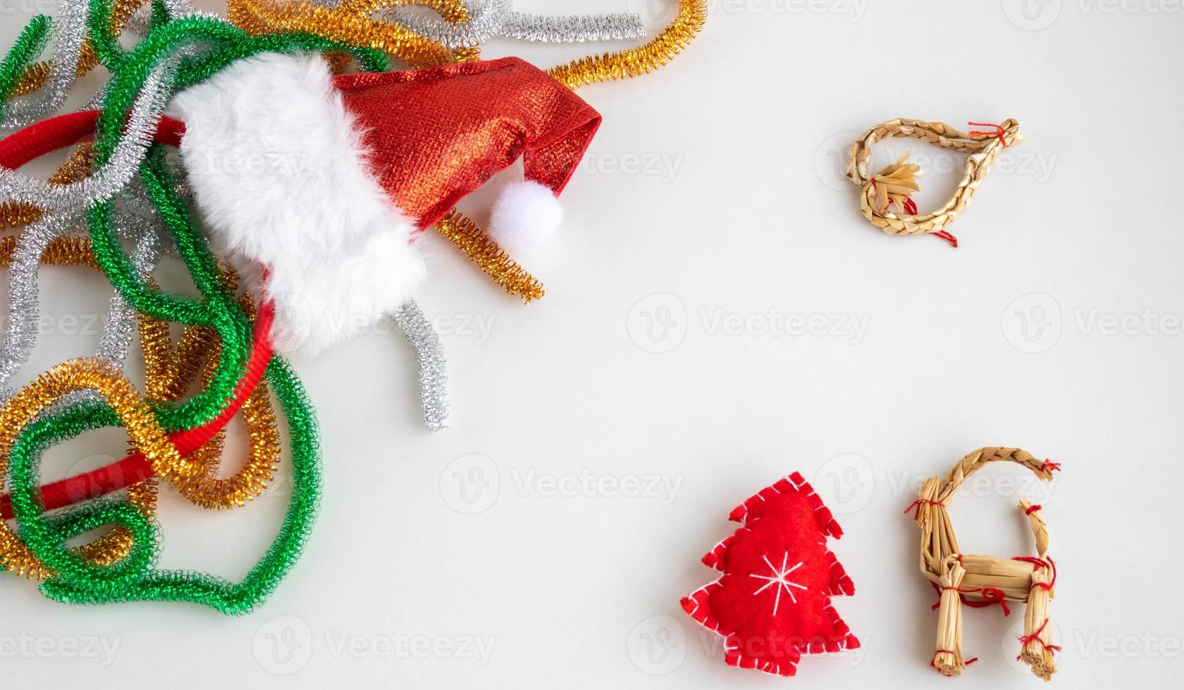 Christmas composition. Tinsel, red Christmas tree, straw toys on a white background. The concept of Christmas, winter, New year. Flat layout, top view, copy space photo