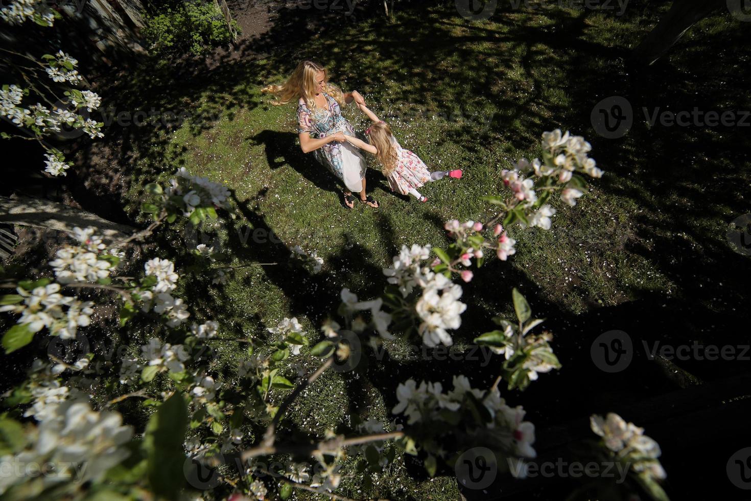 mother twist daughter in the garden photo