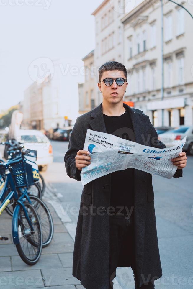 Smart man in sunglasses with paper on street photo