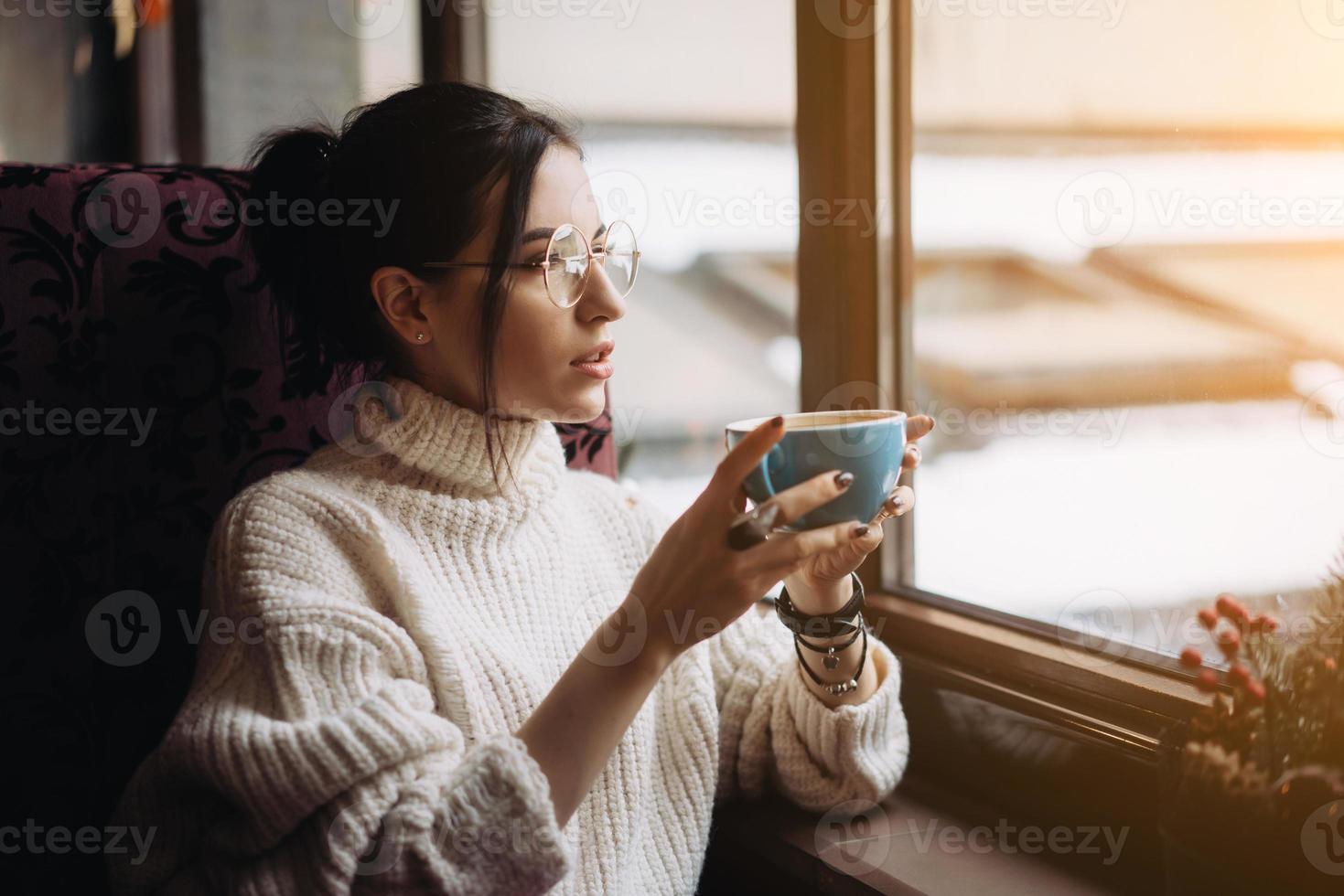 chica disfrutando del sabor del café mientras se relaja en la cafetería foto