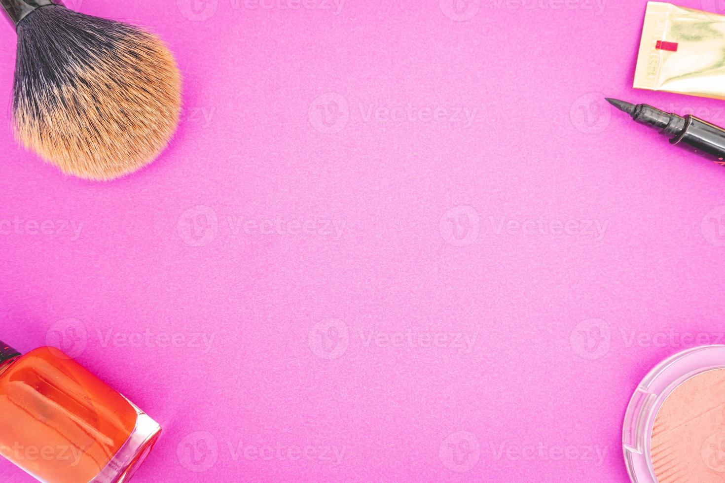 Flatlay of make up and beauty products on a pink background. photo